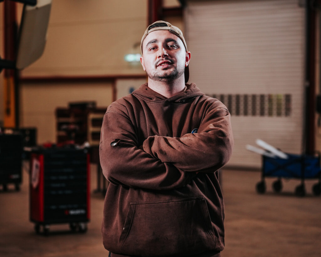 Mitarbeiter mit verschränkten Armen in der Werkstatt