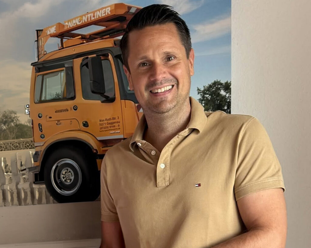Ingo Hurrle lächelnd vor einem Lkw, Kundenstimme